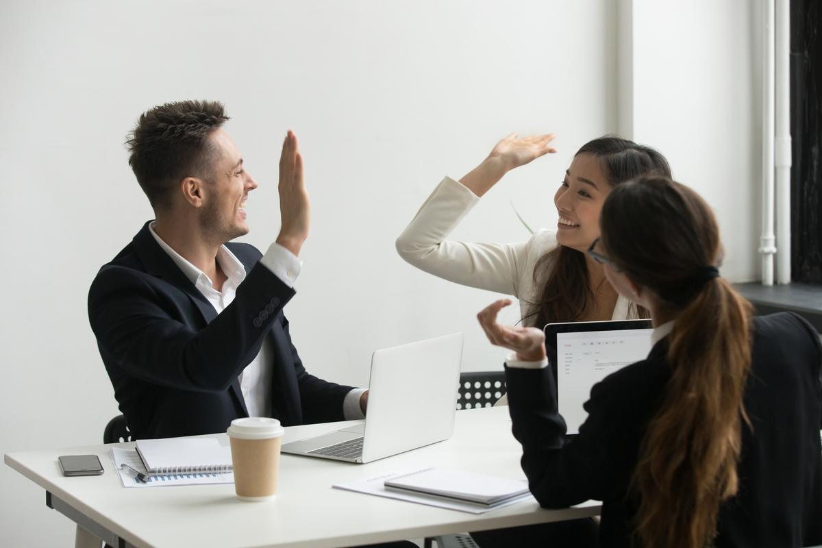 A high-five across the desk, the impact stage